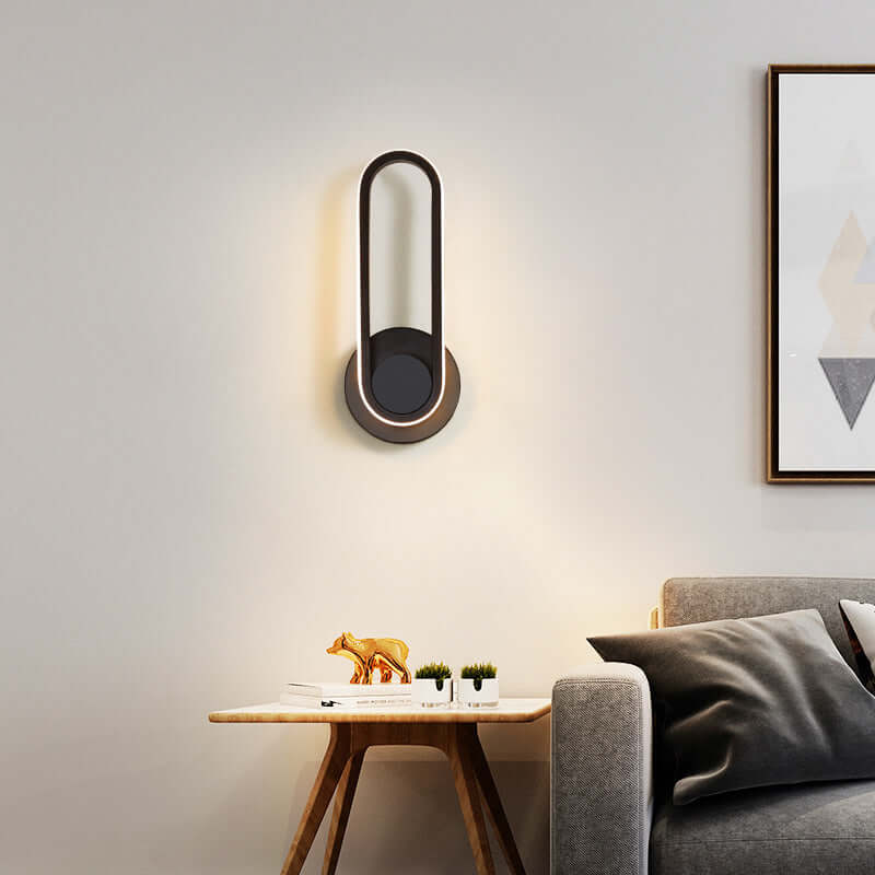 Sleek modern oval wall lamp with warm white light, enhancing a stylish living room setting with high-quality aluminum design.