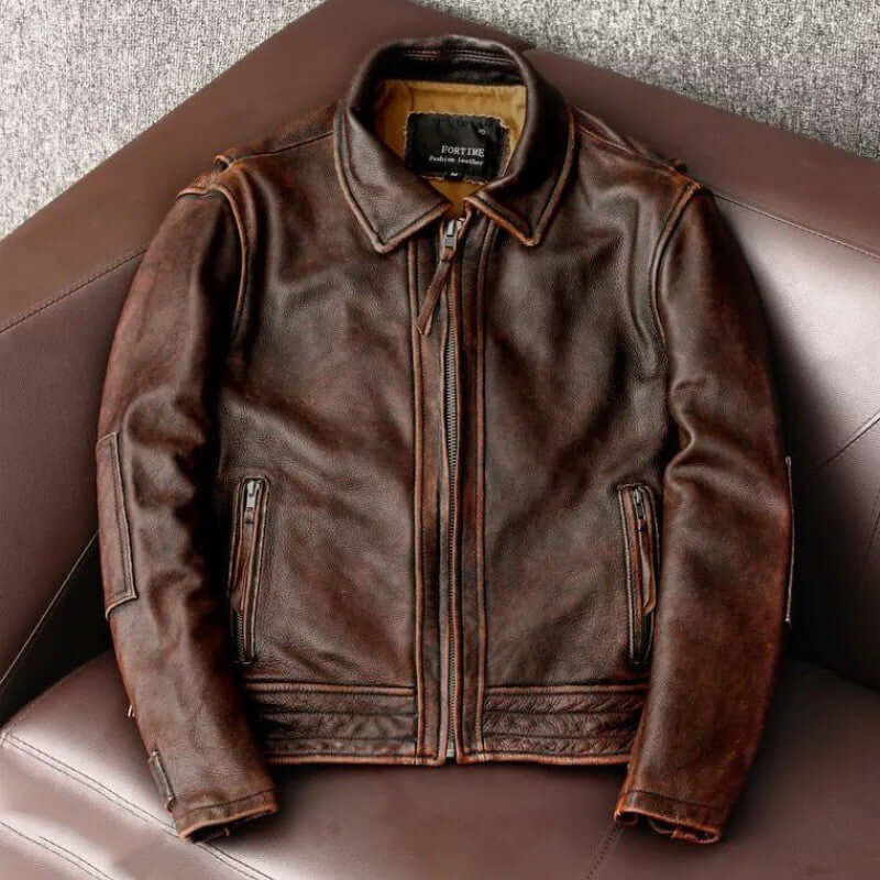 Men's fashionable vintage distressed brown cowhide leather jacket in minimalist style on a chair